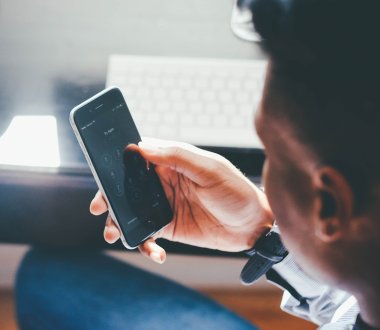 Person mit mobilem Endgerät in der Hand